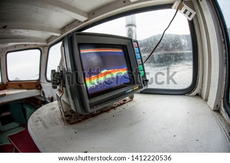 A sonar mounted in a wooden fishing boat, showing the sea bed.