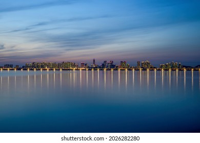 Songdo, Yeonsu-gu, Incheon, South Korea - March 31, 2021: Night View Of High-rise Buildings At Songdo New Town With The Reflection Of Illumination On The Sea
