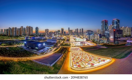 Songdo, Yeonsu-gu, Incheon, South Korea - September 14, 2021: High Angle And Night View Of Umbrella With Illumination At Shopping Mall Of Triple Street Against Highrise Buildings At Songdo New Town
