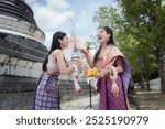 Songkran festival is funny water festival for long holiday in Ayuttaya  Thailand . young women wearing Thai dress traditional  happiness to playing  water during this festival.