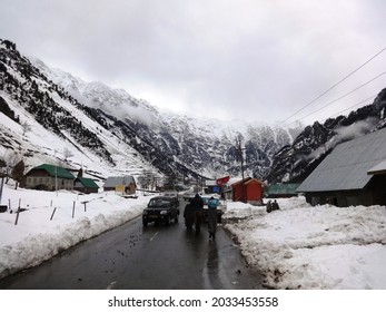 Sonmarg, Kashmir, India - April 2014 : View of a road passing through the snow covered valley with tourists enjoying their vacation					