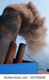 Soot and smoke billowing on the stack of a ship.