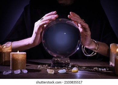 Soothsayer Using Crystal Ball To Predict Future At Table In Darkness, Closeup. Fortune Telling