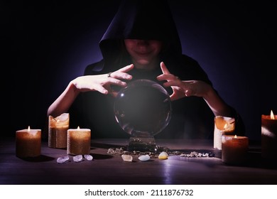 Soothsayer Using Crystal Ball To Predict Future At Table In Darkness. Fortune Telling