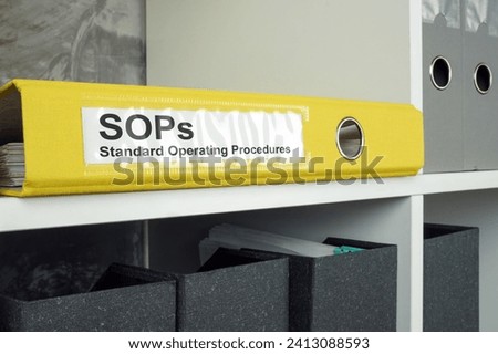 SOP Standard operating procedure concept. A yellow folder lies on an office shelf.