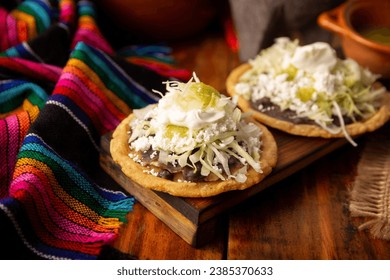 Espadas. Cocina tradicional mexicana casera elaborada con pasta de maíz frita, aplanada y pellizcada, cubierta con judías fritas, salsa verde o roja, lechuga, queso, cebolla y crema agria.