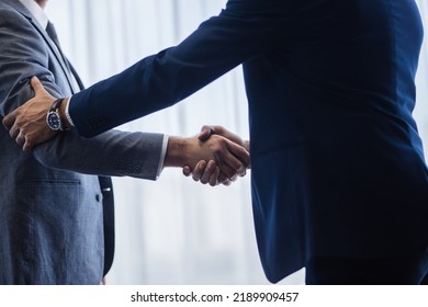 Sophisticated business men shaking hands with each other after a deal. Businesspeople shaking hands and making an agreement. - Shutterstock ID 2189909457