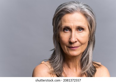 Sophisticated Elderly Woman With Naked Shoulders Isolated On Gray-background. Close-up Portrait Of Well-looking Mature Aged Lady With Gray Silver Hair Looking At Camera With Serious Face