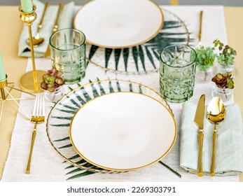 Sophisticated floral table setting. white crockery, golden cutlery and white table linen make a luxury setting. The formal elegant composition is perfect for a birthday banquet, a date or a wedding.  - Powered by Shutterstock