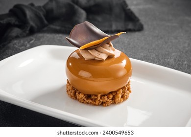 Sophisticated hazelnut praline mousse cake with a smooth glaze and chocolate decor, presented on a pristine white plate. - Powered by Shutterstock