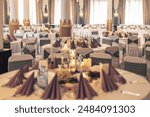 Sophisticated reception setup with decorated tables and modern lighting in a banquet hall