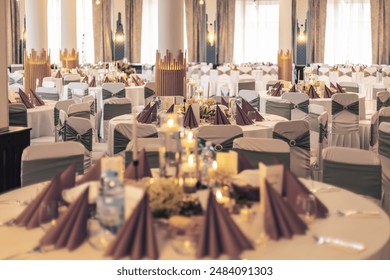 Sophisticated reception setup with decorated tables and modern lighting in a banquet hall - Powered by Shutterstock