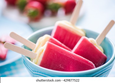sorbet popsicles in bowl, fresh fruits in background