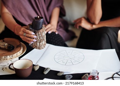 Sorceress burning black candle over natal card of client to ward off bad luck - Shutterstock ID 2179168413