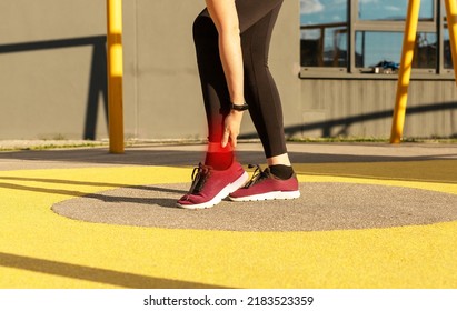 Sore Ankle In Sports. Woman Holding Painful Foot With Red Spot. Ligaments Injury. Health Problems Concept. High Quality Photo