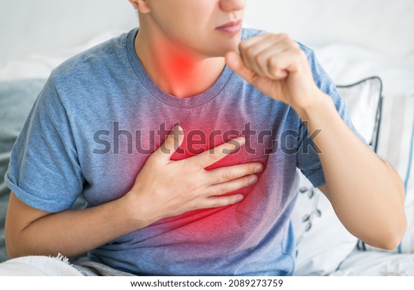 Sore throat and cough, man with lung pain at\
home, health problems\
concept
