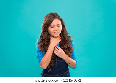 Sore Throat Remedies. Kid Feels Pain In Throat. Girl Cute Kid Suffer From Pain In Neck. Girl Painful Face Stand Blue Background. Health Care And Medicine. Sore Throat Remedies. Throat Pain Treatment.