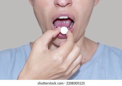 sore throat and runny nose treatment. woman using lozenge candy spray for red painful throat or nose sprayer isolated.girl coughing hold hand on neck or mouth.feeling pain,respiratory virus infection - Shutterstock ID 2208305125