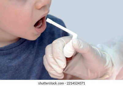 Sore Throat Treatment Concept.cute Baby Boy Preschooler Kid Using Honey Lemon Ingredients Spray For Red Neck Pain.doctor Medical Assistant Hand In Surgical White Glove.smiling Child Home Isolated Mock