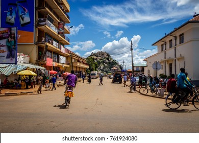 SOROTI, UGANDA – NOVEMBER 04, 2017: Typical street life in Soroti Uganda with its famous rock in the background. Many bicycles and a few cars showing an easy going African town. 