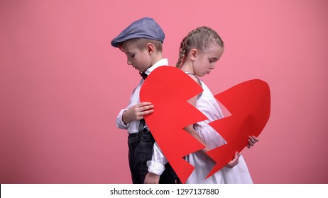 Sorrowful Couple Of Little Kids Holding Broken Pieces Of Red Heart, Brake Up