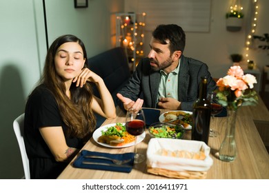 I'm Sorry. Annoyed Husband Trying To Explain Something To His Angry Wife And Apologizing After A Fight During A Fancy Dinner At Home