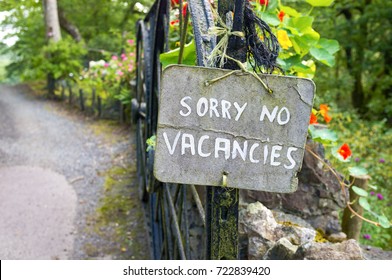 "Sorry No Vacancies" sign in garden of a bed and breakfast.