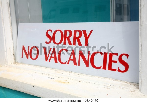 Sorry no\
vacancies sign in a guesthouse\
window.