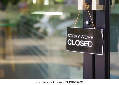 "sorry we're closed" label in front of glass door at the coffee shop to notice customer service                              - Shutterstock ID 2112890960