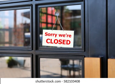 Sorry we're CLOSED sign board hanging on door of cafe. - Shutterstock ID 582103408
