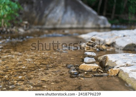 sort arrange stones or stack pebble stone tower or pyramid on rock in water and flow stream or river for balance training meditation concentrate on nature summer relax in garden forest with copy space