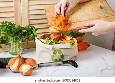Sorted kitchen waste in paper eco bag on kitchen counter top. Compost-container. Sustainable life style. Woman throws vegetable and fruit peels, scrap from food preparation in trash-pack for recycling