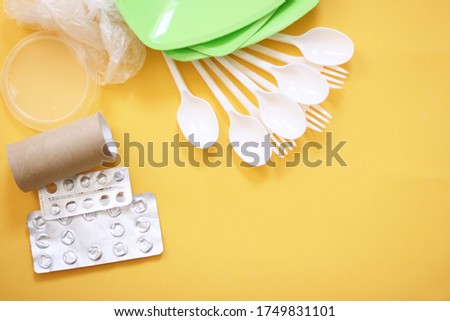 Sorting garbage consept. Trash on a yellow background: glass, plastic, organic trash, paper. 