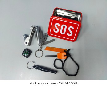 SOS Kit. 6 In 1 Emergency Box. SOS Survival Emergency Gear Self Help Outdoor Camping Hiking Tools Box Kit Set In White Background.