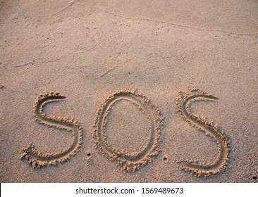 SOS - Word Drawn On The Sand Beach 