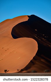 Sossusvlei desert - sand dunes with dramatic abstract shapes and high contrast between shadows and lights - touristic destination namib desert - namibia africa