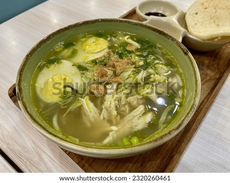 Soto ayam Surabaya. The traditional Indonesian soup originated from Surabaya. Its contains shredded chicken, boiled egg, green onion, celery, fried shallots, chicken broth soup. Bogor, Indonesia. 2023