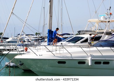 SOTOGRANDE, SPAIN - JULY 18, 2008 - Man cleaning a yacht in the marina, Puerto Sotogrande, Cadiz Province, Andalucia, Spain, Western Europe, July 18, 2008.