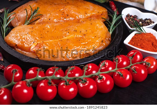 Sottilissime raw fillet with spices and\
rosemary for grilling . Raw meat in the marinade. Marinated Chicken\
Breast with spices and\
rosemary.