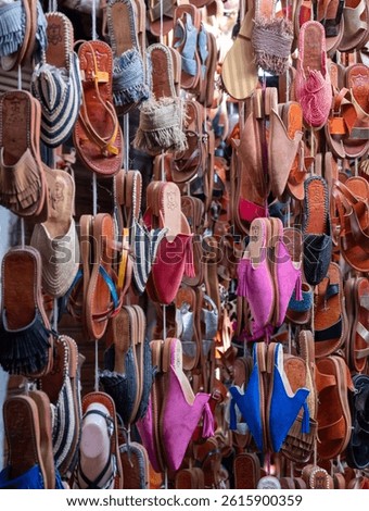 Souk scene with colourful sandals for sale in the old town medina in Marrakech, Morocco. 