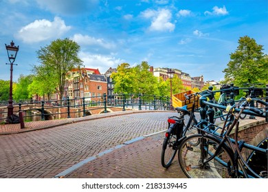 The soul of Amsterdam in one photo - leaning houses, bridges, canals, bicycles and lanterns. View of the famous old center of Amsterdam. Amsterdam, Holland, Europe