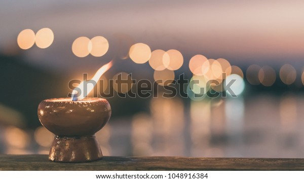 Soul and
spirituality abstract concept  for mourning and world human spirit
day with warm candle light bokeh illumination, golden sunset sky
and reflective river wave
background