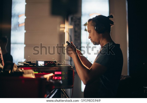 Sound engineer\
with a microphone on the set. A professional sound engineer at work\
on the filming of a movie, commercial or TV series. Filming process\
indoors, studio
