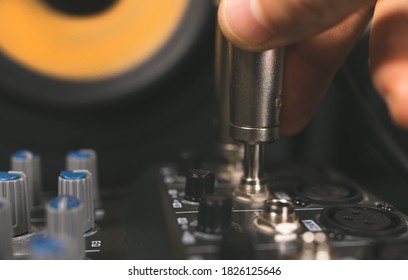 Sound engineer plugging jack audio cable on studio mixer. - Shutterstock ID 1826125646