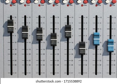 Sound mixing desk faders. Music studio recording equipment volume close-up image with peak LED and stereo master sliders. Home recording for musicians.
