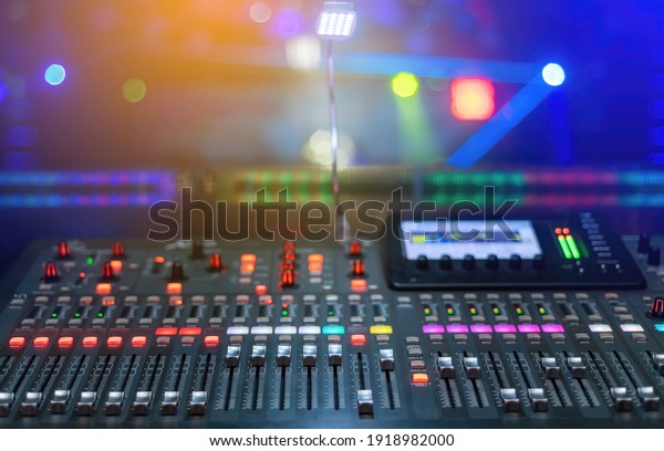 A sound
mixing plan for mixing music with lots of buttons and a lighted
screen and a nightclub stage
background