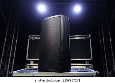 A sound speaker standing on boxes with concert equipment