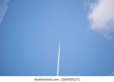 A sounding rocket blasts off into the clear sky above the New Mexico desert, leaving behind a trail of smoke as it ascends, capturing the power and excitement of space exploration.