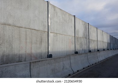 soundproof wall made of concrete porous ribbed material. fence of gray blocks embedded in metal beams, on street. road traffic noise  garden and residential area. protection of Jerusalem, rocket