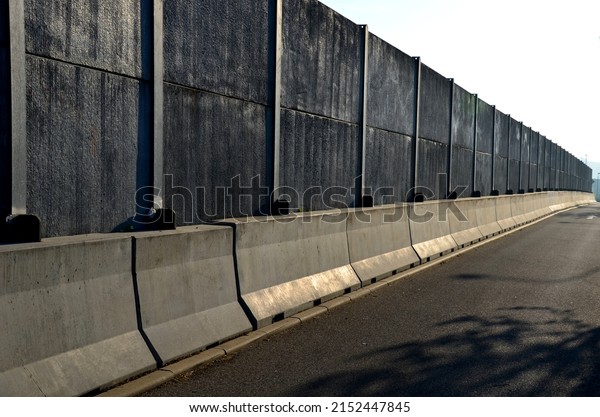 soundproof wall made of concrete porous ribbed\
material. fence of gray blocks embedded in metal beams, on street.\
road traffic noise  garden and residential area. protection of\
Jerusalem, rocket